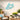 Turquoise butterfly wall art on a light stone wall with outdoor furniture and plants.