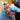 Person cleaning a multicolored mosaic object with blue gloves