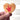 Wooden heart-shaped object with a red hand sign on a white background