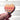 Heart-shaped colorful makeup palette held by a hand against a light background