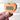 Wooden heart-shaped object with 'XOXO' embroidery held by a hand against a white background