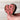 Wooden heart-shaped object with 'LOVE' spelled out in pink letters held by a hand.