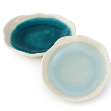 Two ceramic bowls with blue and light blue interior colors on a white background