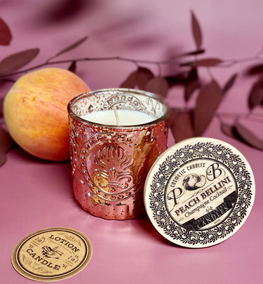 Peach Bellini Soy Candle in Blush Mercury Glass Jar with peach and branded coaster on a pink background