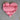 Pink heart-shaped object on a textured surface