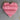 Pink heart-shaped object on a textured surface