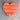 Orange heart-shaped object on a textured surface