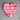 Pink heart-shaped object on a beige surface