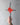 Hand holding a cross with a red heart design against a gray background