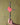 Hand holding a cross made of barbed wire with a red heart attached against a green background