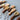 Wooden keychains shaped like maracas on a textured surface