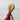 Hand holding a wooden toy with a colorful design against a plain background