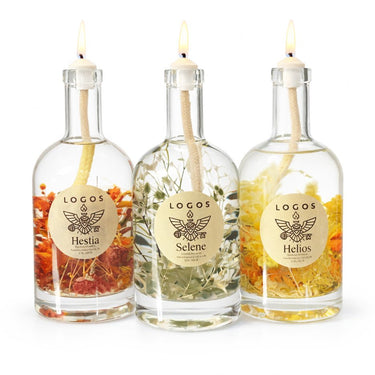 Three glass bottles with lit candles inside, each labeled with a different name, on a white background.