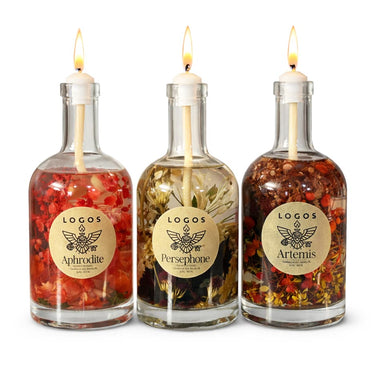 Three lit candles in glass bottles labeled 'Logos' with different names on a white background