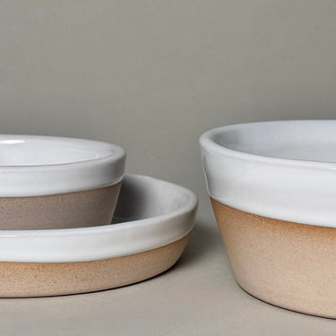 Set of ceramic bowls with white and beige gradient on a neutral background