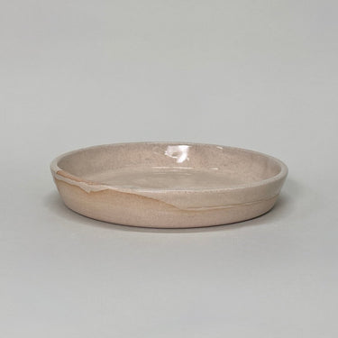 Beige ceramic bowl on a light gray background