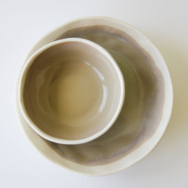 Two ceramic bowls, one inside the other, on a white background