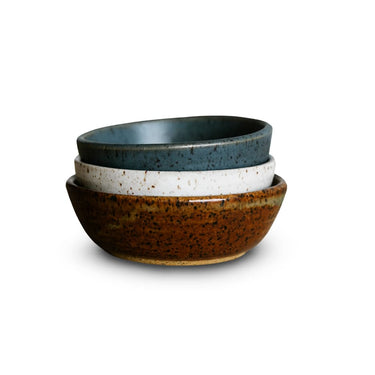 Set of three ceramic bowls with different finishes on a white background