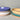 Stacks of ceramic bowls with different colored rims on a neutral background