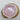 White ceramic bowl with pink interior on a wooden base