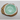 Green substance in a white dish on a wooden coaster