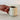 Hand holding a beige ceramic mug with coffee on a light surface