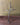 Decorative metal Promise Cross with a heart and branch design on a wooden surface