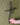 Hand holding a metal Promise Cross with heart against a green background