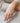 Close-up of a hand wearing a bracelet on a textured fabric background