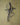 Metal heart-shaped wall cross art on a textured green wall