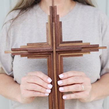 Walnut Layered Wooden Cross held by a person with a neutral background