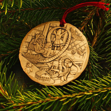 Decorative Christmas ornament with intricate designs on a green pine branch.