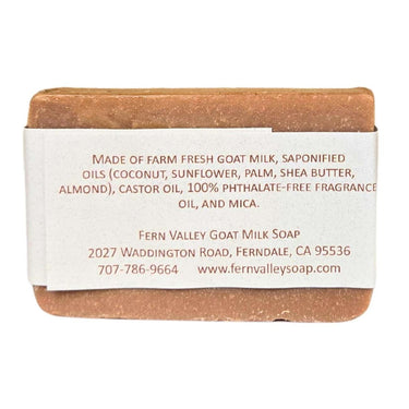 Bar of Almond Macaroon handmade goat milk soap bar with a label detailing ingredients and contact information on a white background
