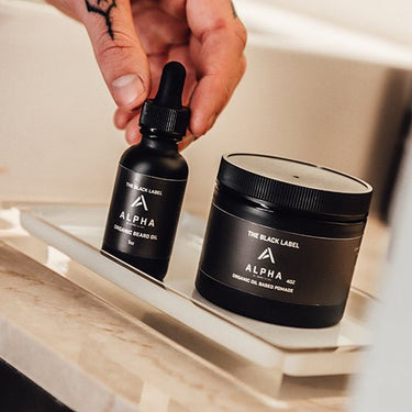 Black labeled Alpha grooming products on a bathroom counter.