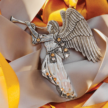 Decorative angel figurine with wings on a ribbon background
