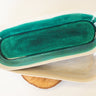 Ceramic butter dish with green interior and beige exterior on a white background