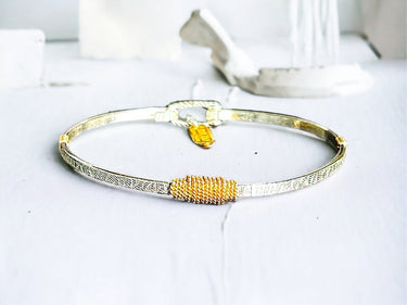 Gold bracelet on a white surface