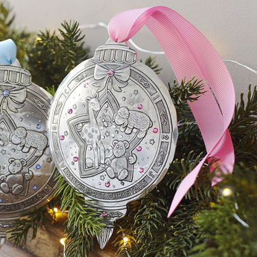 Silver Christmas ornament with pink ribbon on a tree