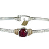 Silver bracelet with a red Crystal on a white background