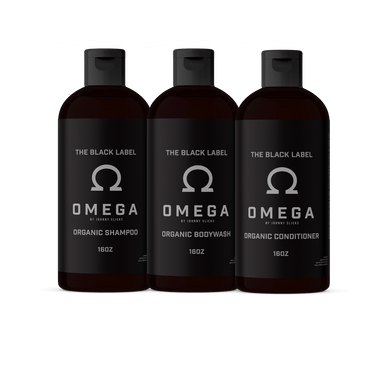 Three bottles of Omega 'The Black Label' organic shampoo, bodywash, and conditioner on a white background.