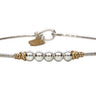 Silver bracelet with gold accents on a white background