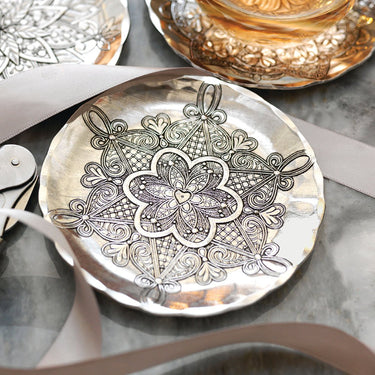Decorative plate with intricate floral design on a marble surface