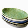 Stack of ceramic plates with textured surface on a white background