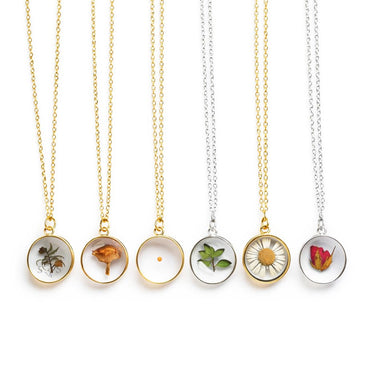 Set of necklaces with circular pendants featuring pressed flowers on a white background
