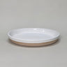 Ceramic dish with white top and beige bottom on a gray background