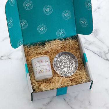 Gift set with candle and decorative bowl in a box on a marble surface