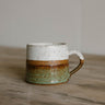 earthenware mug with two-tone design on a wooden surface