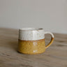 earthenware Mug with speckled design on a wooden surface
