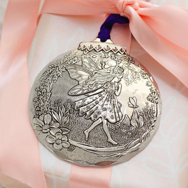 Decorative medal with fairy design on a pink ribbon