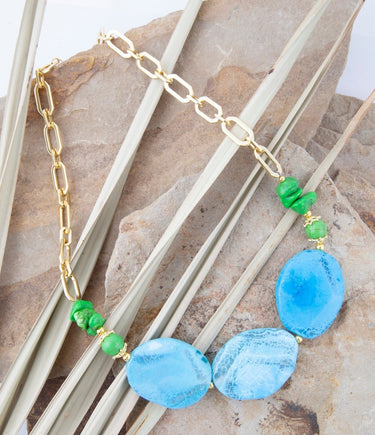 Necklace with blue and green beads on a natural stone background